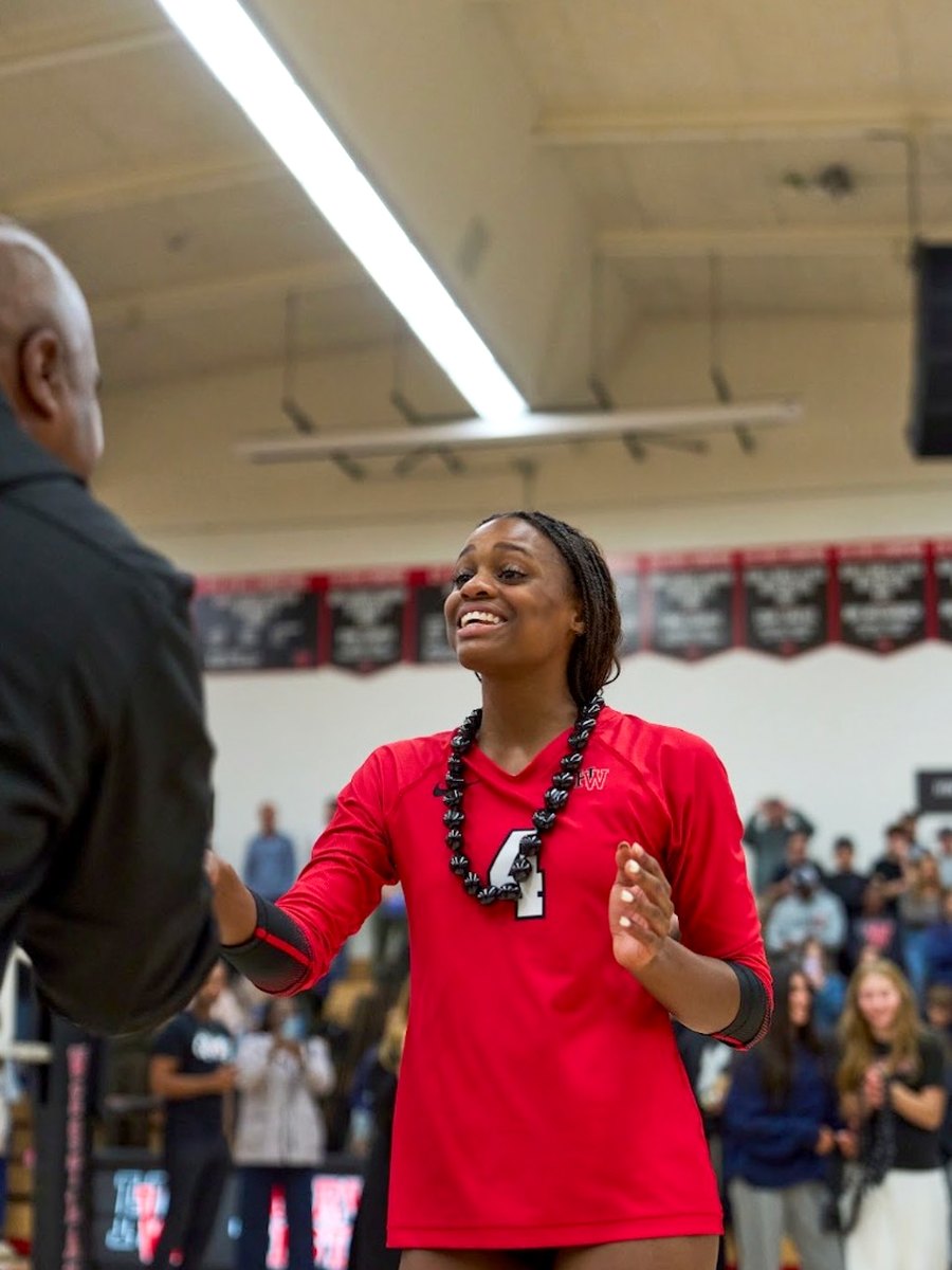 Lauryn Lewis smiling and shaking hands during a team recognition ceremony.
